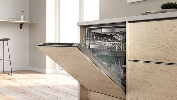Uma máquina de lavar loiça totalmente integrável num armário de madeira.