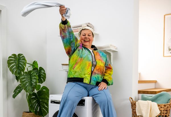 Woman sitting on top of a washing machine