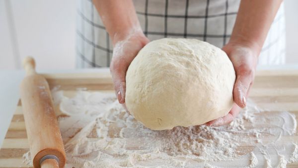 Kneading dough on a kitchen top of flour