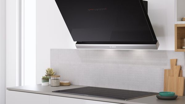 A black wall mounted hood in a bright modern kitchen.