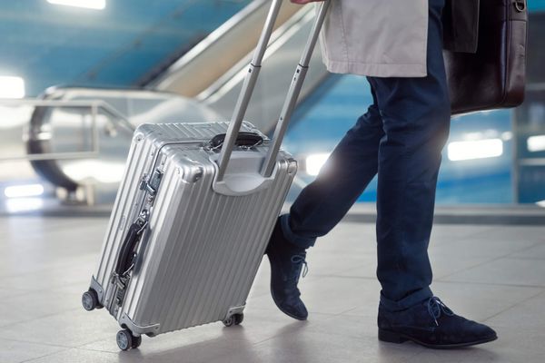 Un homme court avec une valise dans un aéroport.