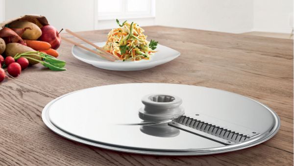 El disco asia o de corte en juliana se puede comprar como un accesorio adicional de Cookit y puede cortar frutas y verduras en tiras finas.