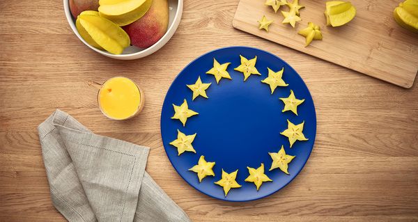 Slices of star fruit are placed on a blue plate to imitate the European flag.