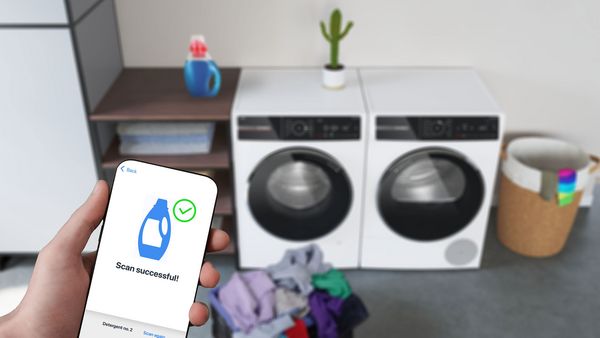 Embalaža tekočega detergenta, ki stoji na pralnem stroju serije 8. Pred njo je pametni telefon, ki skenira embalažo.