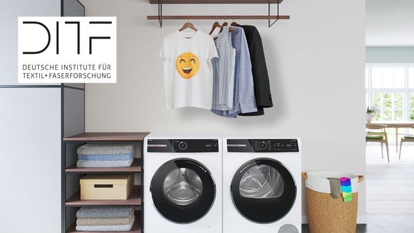 Una lavadora Serie 8 junto a una secadora también Serie 8. Con prendas sin arrugas colgadas encima sobre perchas. Una camiseta tiene un smiley sonriente.