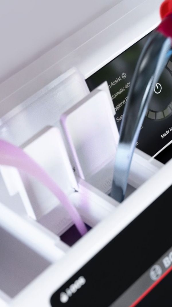 Detergentul şi balsamul de rufe sunt turnate în compartimentul pentru detergent al maşinii de spălat rufe din Seria 8.