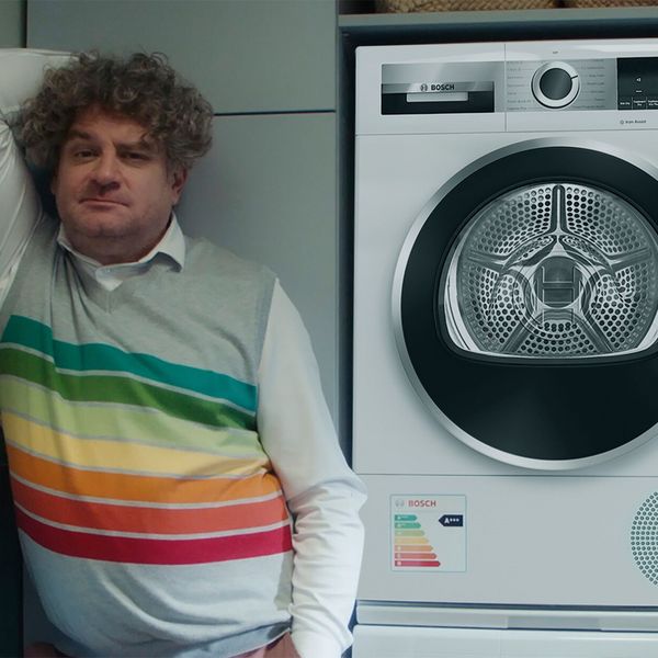 Man met energielabel op trui naast Bosch warmtepompdroger