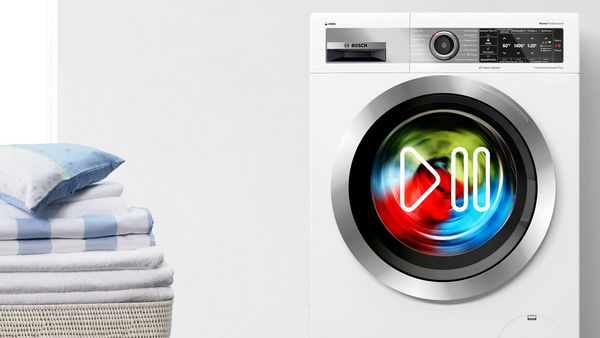 Colourful clothes spinning inside a Bosch washing machine.