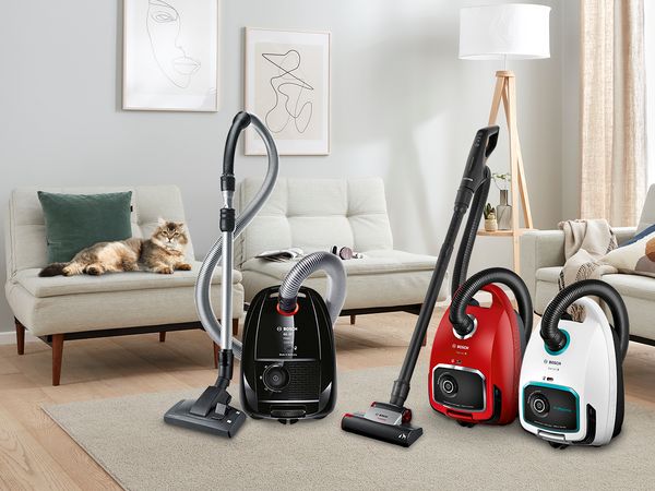 Wing doors opening into a spacious living room with a Bosch bagged vacuum picking up dirt on a high-pile rug