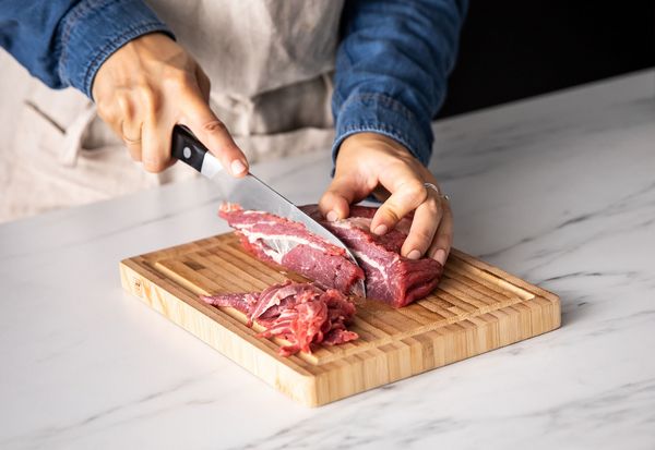 Cutting flank steak on cutting board