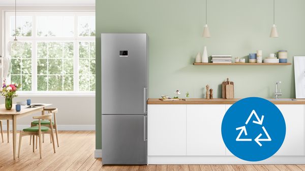 Eine helle, moderne und offene Küche mit einem silbernen Kühlschrank, davor ein blauer Kreis mit 3 weißen Pfeilen.