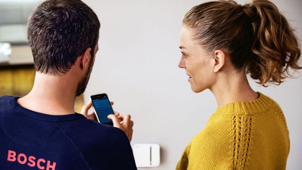 Ein Mann zeigt einer Frau etwas auf einem iPhone.