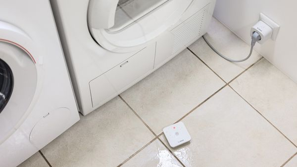 Der Bosch Wassermelder auf einem nassen Boden in der Waschküche.