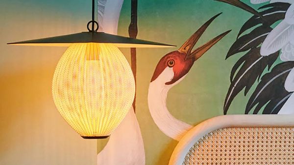Ein Wandbild mit einem großen Vogel und einer stylischen Lampe im asiatischen Stil.