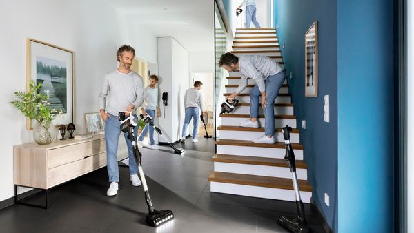 A second Bosch battery charging in fast charger next to an Unlimited handheld vacuum.