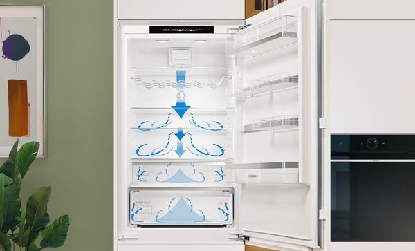 Otevřená a prázdná integrovaná XXL chladnička s mrazákem. Modré šipky označují proudění vzduchu v chladničce.