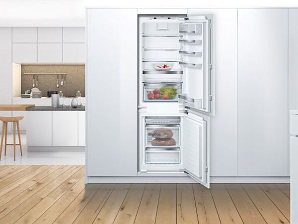 Built-in Bosch fridge with open door showing fresh food and drinks inside.