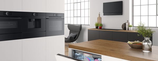 Oven, afzuigkap en inbouwapparatuur in een lichte moderne keuken met frameloze kasten