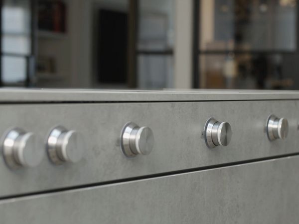 A line of Gaggenau control knobs mounted on the front of kitchen furniture 