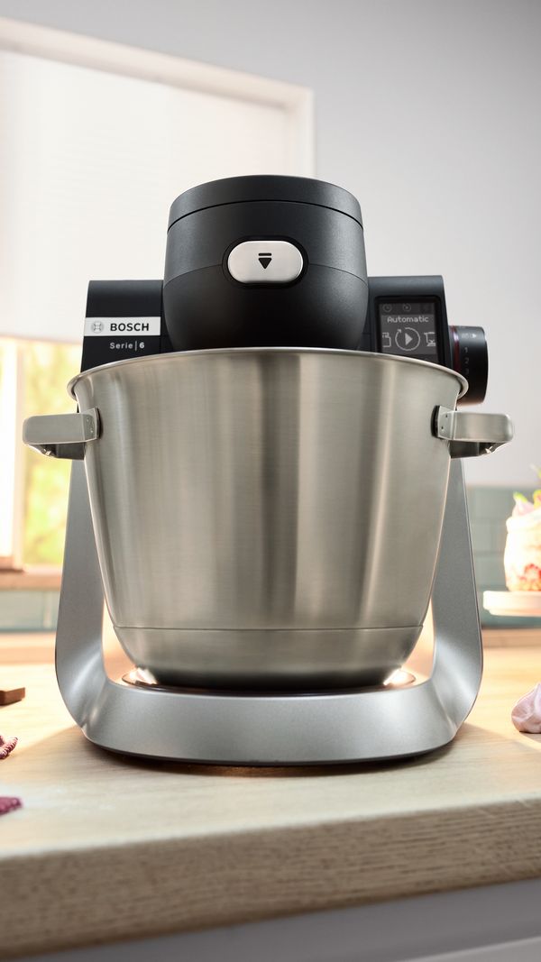 Close-up front shot of Series 6 stand mixer  with large stainless steel mixing bowl and LED display showing 'automatic'.