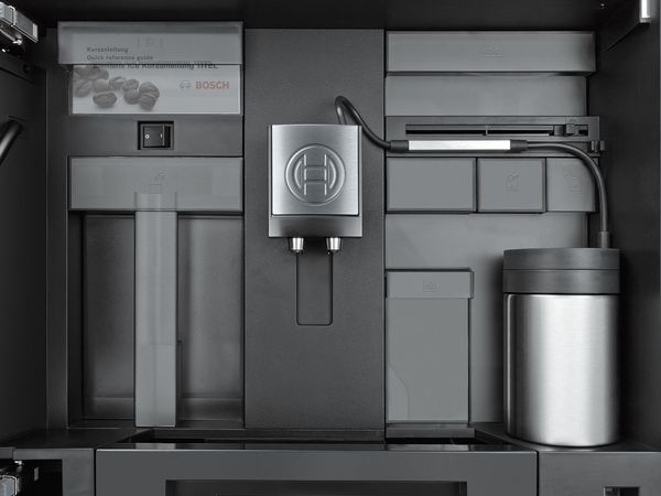 Open built-in Bosch coffee machine showing milk system in use