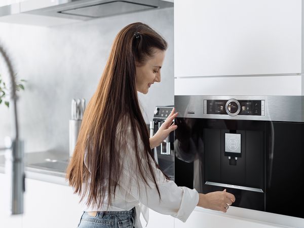 Woman using a Bosch built-in coffee machine
