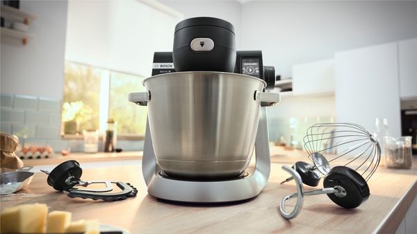 Kuhinjski robot serije 6 na kuhinjskoj radnoj površini i set za pripremu slastica pored njega.