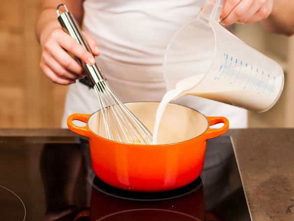 Mixing milk into the pan with a whisk