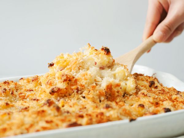 Scooping mac and cheese out of baking pan