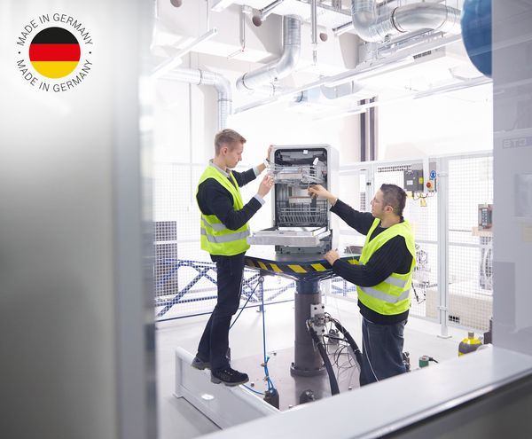 Zwei Bosch Techniker prüfen ein Bosch Gerät mit High-Tech; Made in Germany-Logo