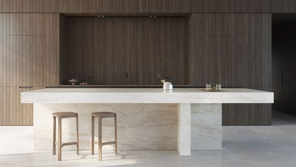 Large luxury kitchen island with a kettle being heated by a unseen induction cooktop
