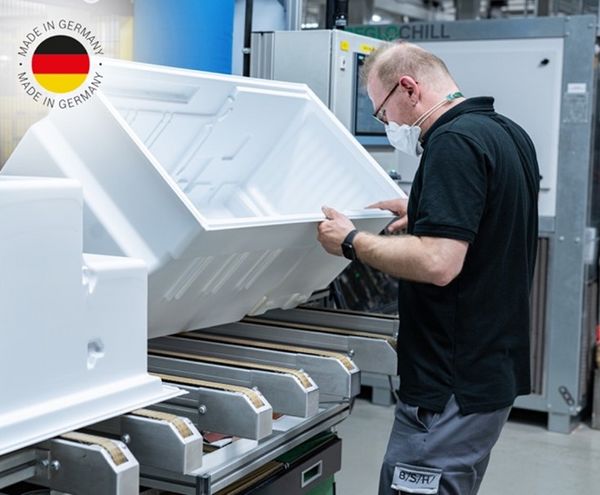 Bosch-Techniker prüft die Qualität eines Einbau Kühl- und Gefrierschranks von Bosch; Made in Germany-Logo
