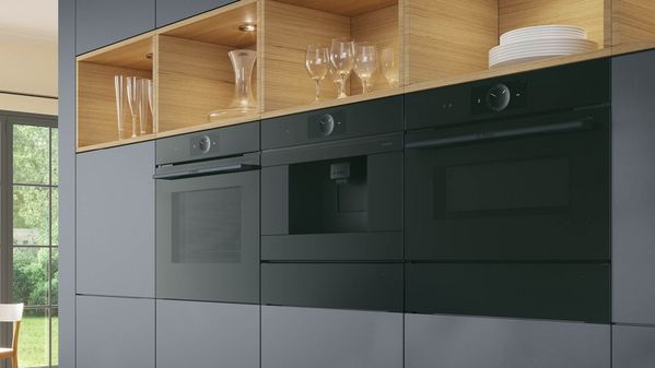 Drei schwarze Back&ouml;fen in einer Einbauk&uuml;che.