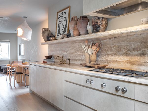 A light, warm coloured kitchen with pared-back tones fitted with Gaggenau appliances