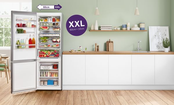 XXL-Kühlschrank mit Gefrierfach in einer Küchenzeile vor einer mintgrünen Wand.
