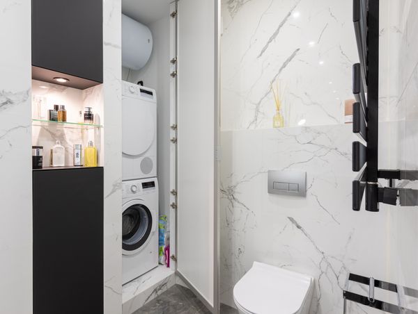 łazienka z pralką i suszarką w słupku, ukryte w zabudowanej szafce