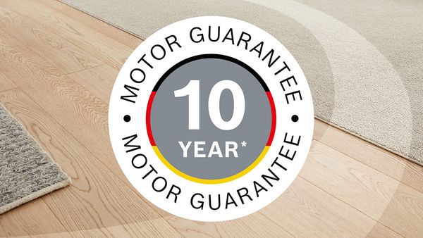 A teaser saying "10-year motor guarantee" and featuring the colours of the German flag is superimposed on a shot of carpet and wooden flooring.