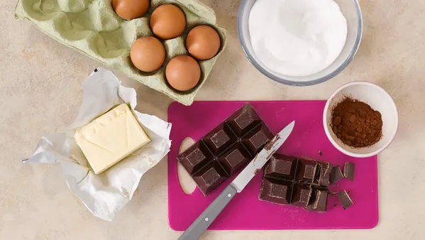  A view from above of a carton of eggs, butter and other baking ingredients. 