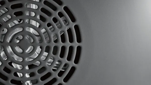 A close up of an oven's specially coated rear wall with the convection fan visible through a grill.