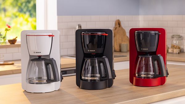 Μηχανές καφέ MyMoment σε λευκό, μαύρο και κόκκινο χρώμα πάνω στον πάγκο μιας κουζίνας.