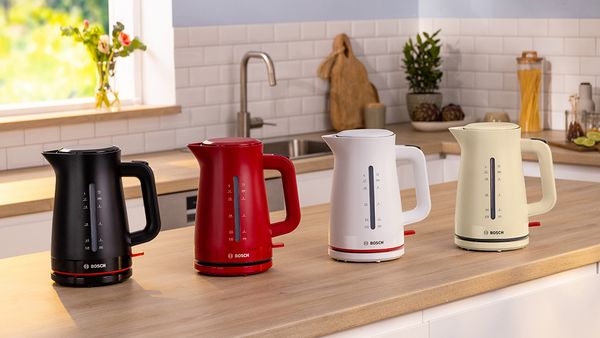 Black, red, white and cream MyMoment kettles on kitchen counter.