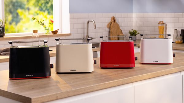 Black, cream, red and white MyMoment toasters on kitchen counter.