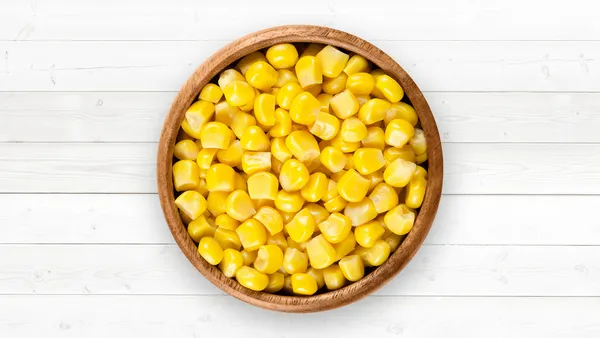 A brown bowl of corn kernels.