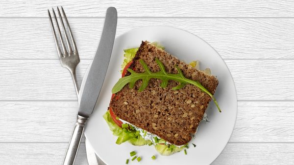  Ein Weizenvollkorn-Sandwich auf einem Teller mit Messer und Gabel. 