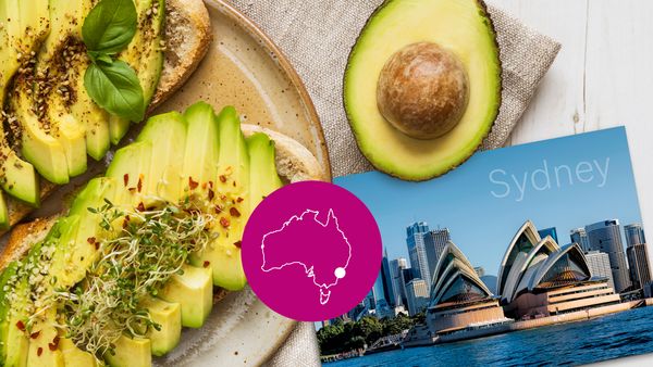 Eine winzige Karte von Australien überlagert eine Draufsicht auf einen Teller mit Avocado-Scheiben auf Toast und eine Postkarte aus Sydney.