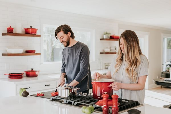 Kobieta i mężczyzna w kuchni razem przyrządzają posiłek.