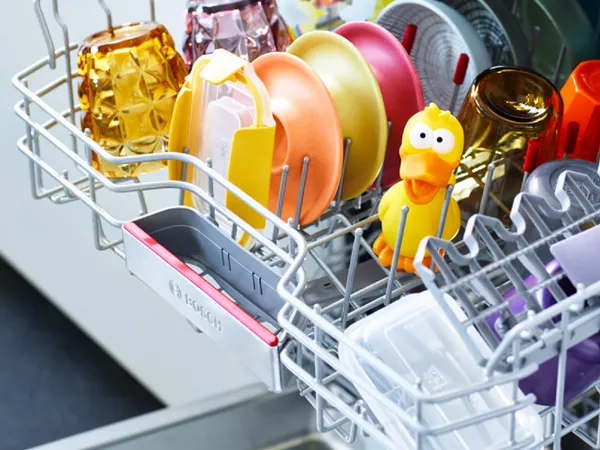 otwarte drzwi zmywarki, w srodku naczynia