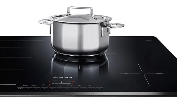 A stainless steel cooking pot on a ceramic cooktop.