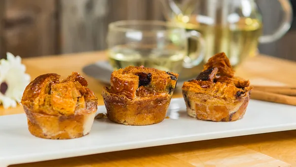 Three eggnog, bread and butter puddings on a white platter.