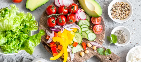 Salad ingredients on a cutting board and in bowls.